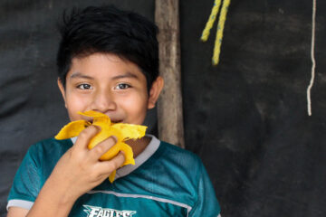 Niño, habitante de Yucatán, comiendo un mango.