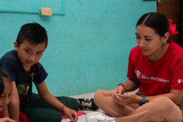 Miembro de nuestro staff ayudando a niñas y niños.