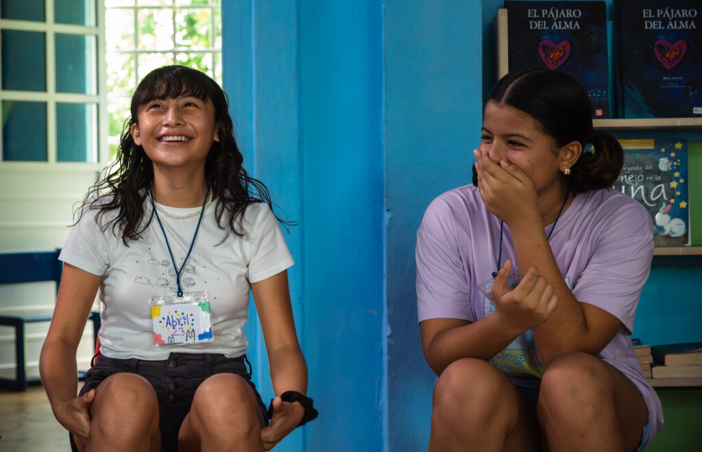 Dos niñas ríen durante una actividad de convivencia