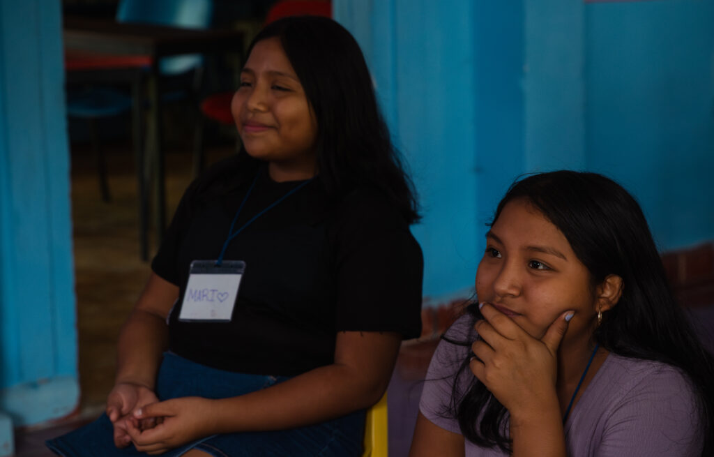 Dos niñas sentadas participando en una actividad de Save the Children