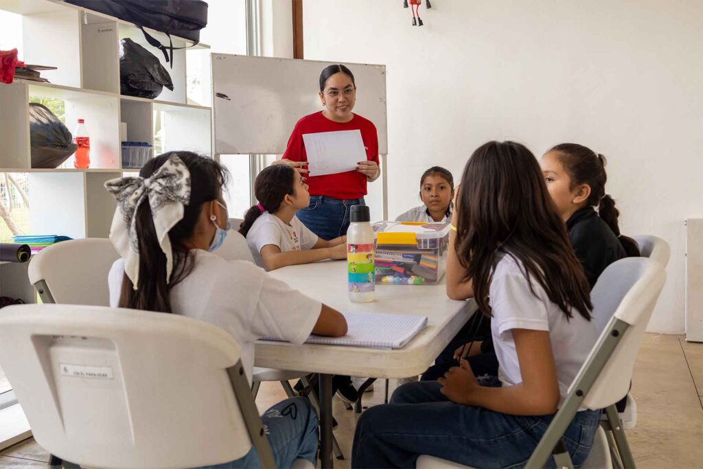 Ninas sentadas en una mesa realizando actividad