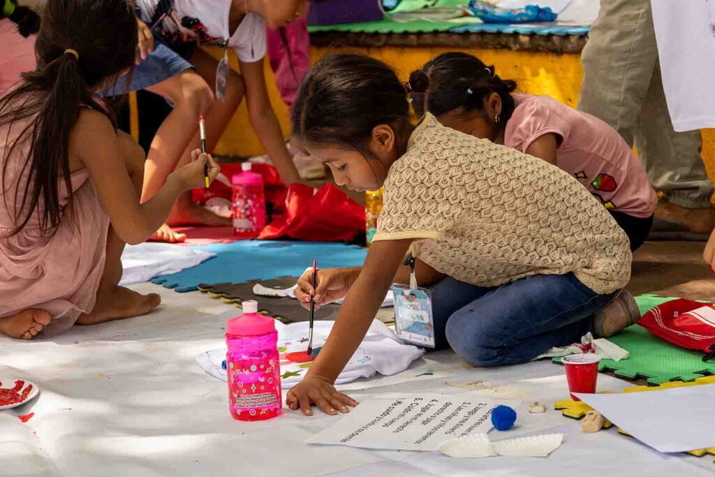 Nina sentada en el suelo pintando