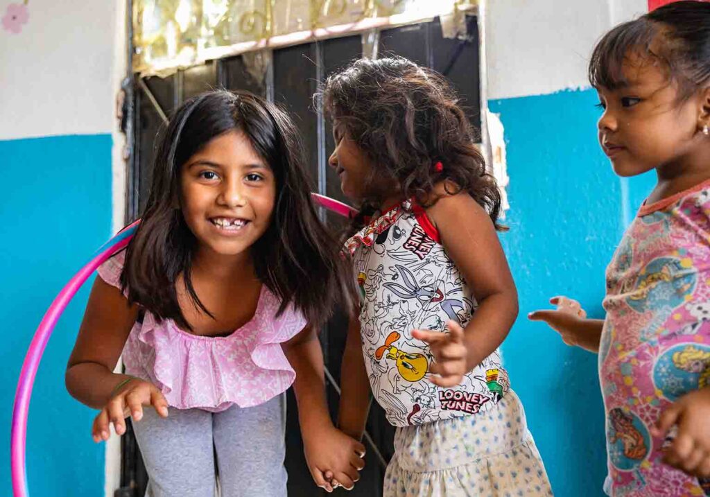 Grupo de niñas jugando y sonriendo.