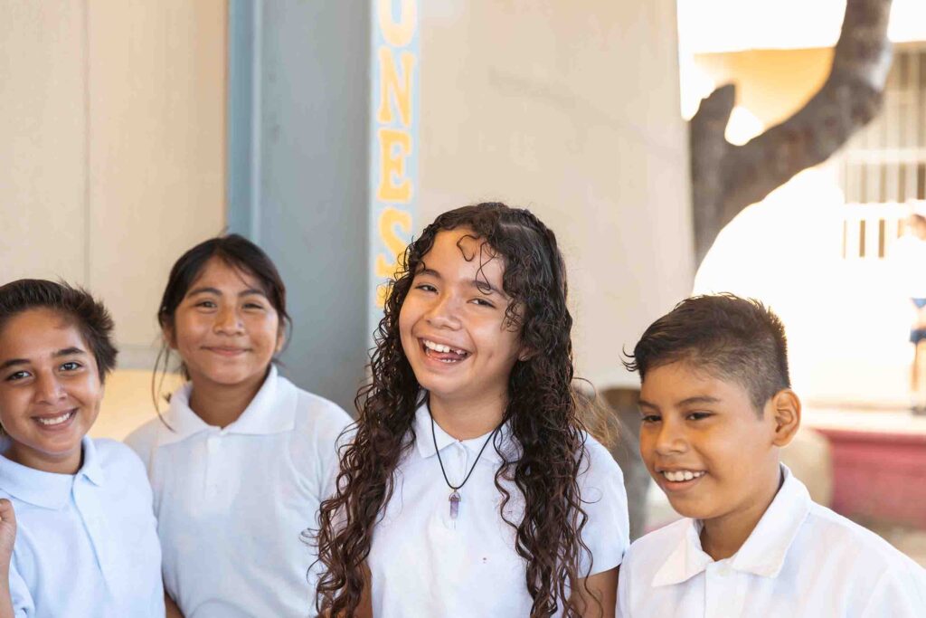 Grupo de niñas y niños sonriendo a cámara.